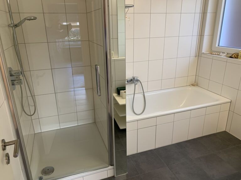 Badezimmer mit Badewanne und Duschbereich